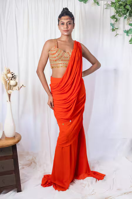 Orange draped saree with mirror work choli