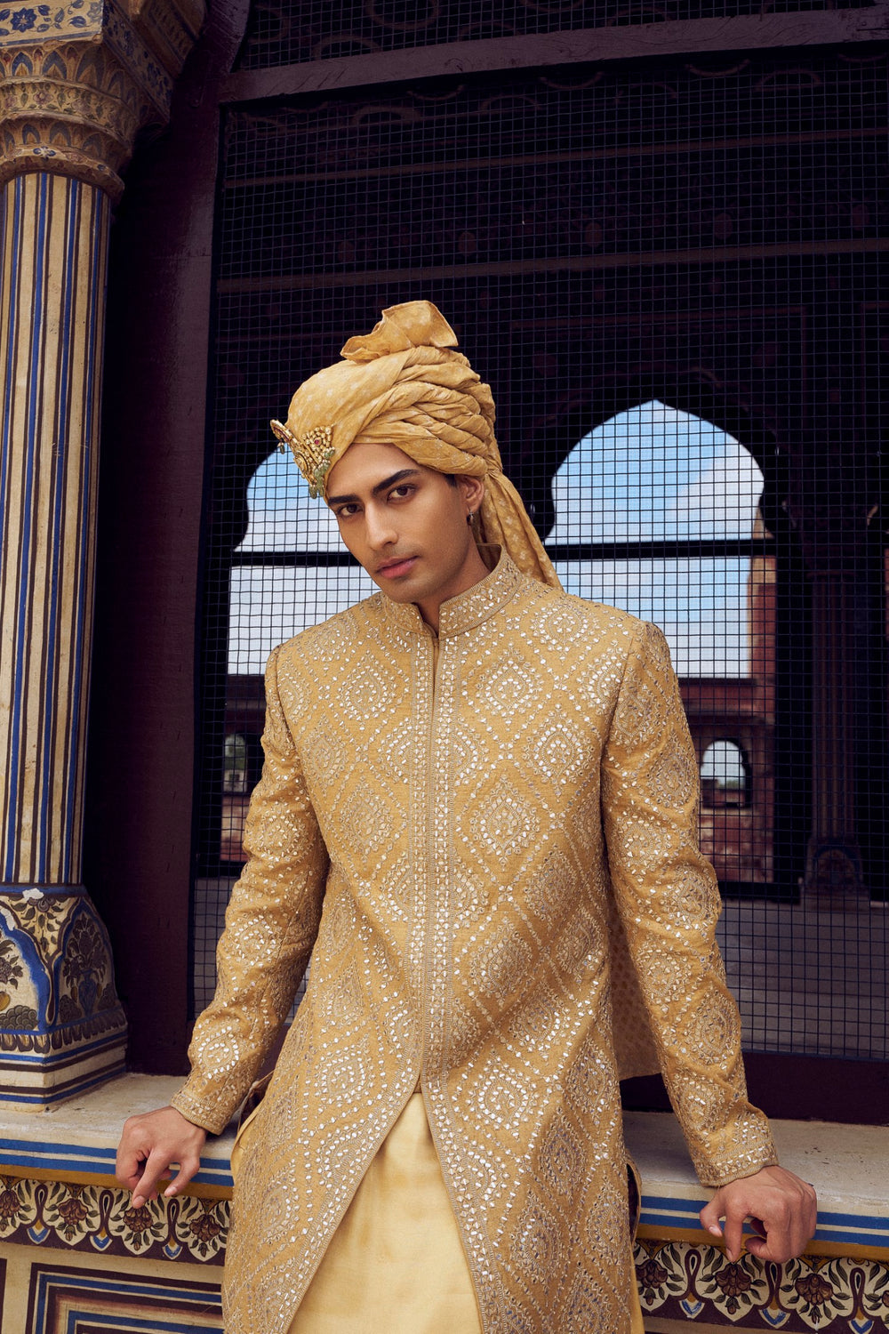 GOLD RAW SILK SHORT SHERWANI WITH A SATIN KURTA AND DHOTI WITH AN OPTIONAL WORKED STOLE AND JUTIS