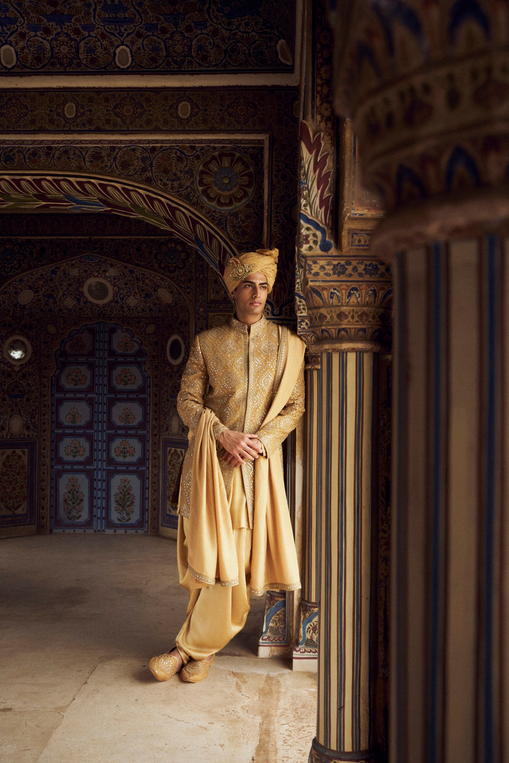 GOLD RAW SILK SHORT SHERWANI WITH A SATIN KURTA AND DHOTI WITH AN OPTIONAL WORKED STOLE AND JUTIS