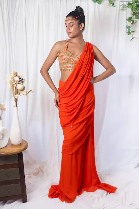 Orange draped saree with mirror work choli