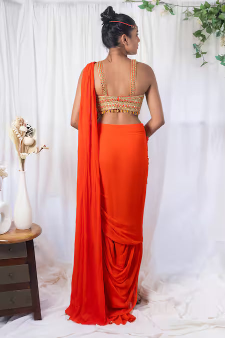 Orange draped saree with mirror work choli