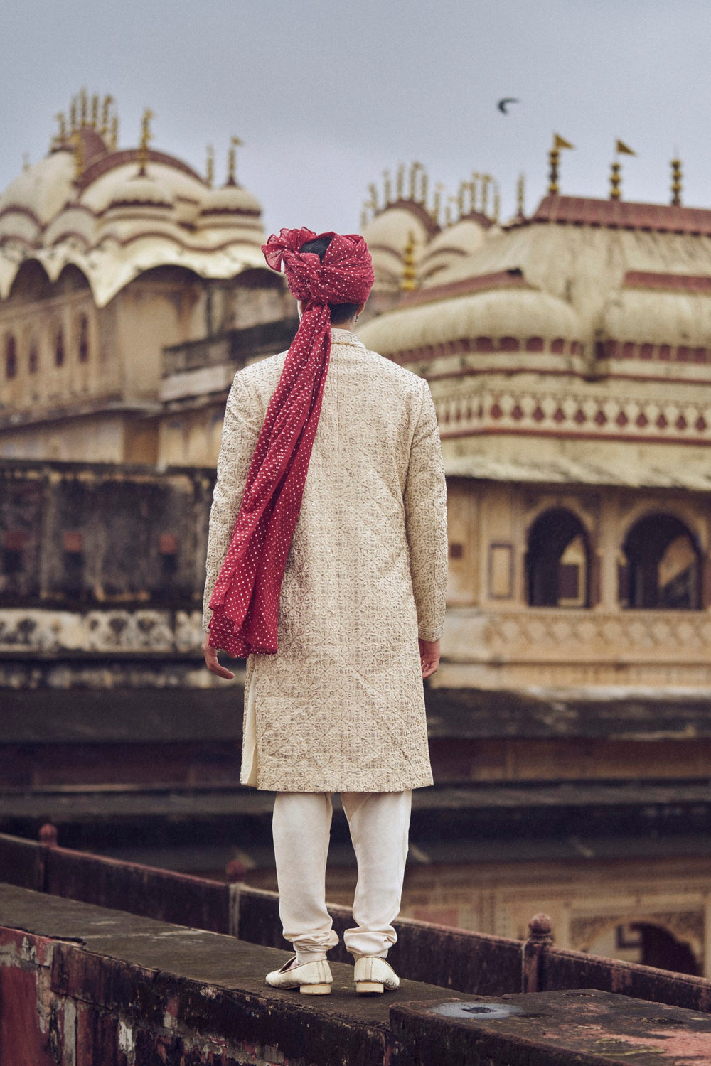 LIGHT BEIGE RAW SILK SHERWANI WITH KURTA AND CHURIDAR. IT COMES WITH AN OPTIONAL BELT, STOLE AND JUTIS