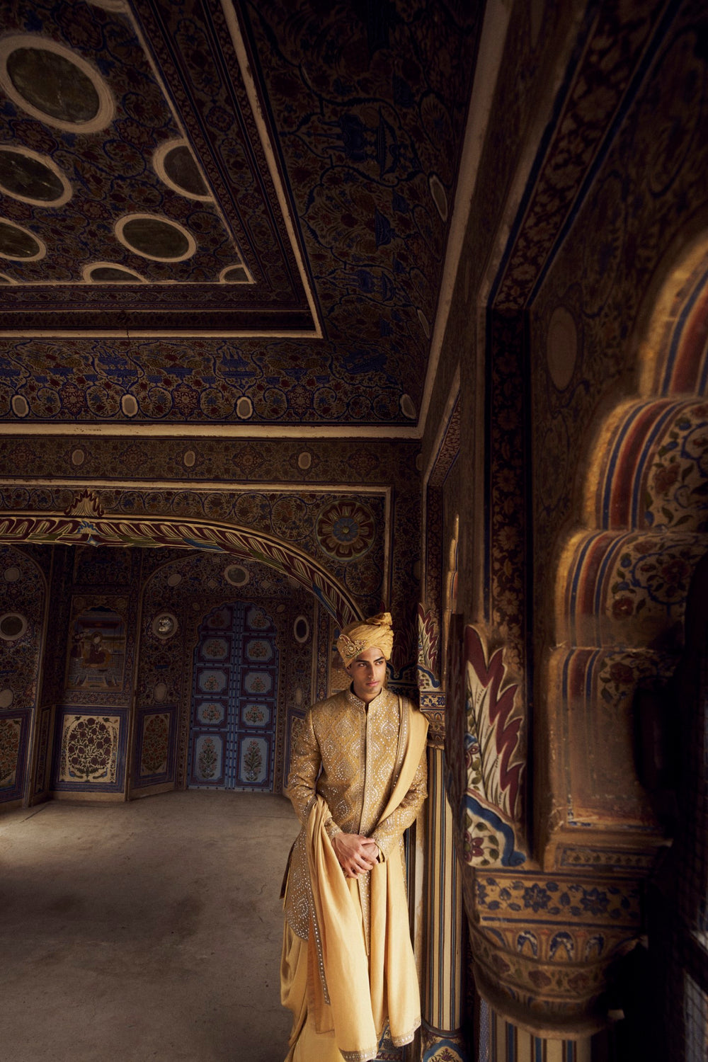 GOLD RAW SILK SHORT SHERWANI WITH A SATIN KURTA AND DHOTI WITH AN OPTIONAL WORKED STOLE AND JUTIS