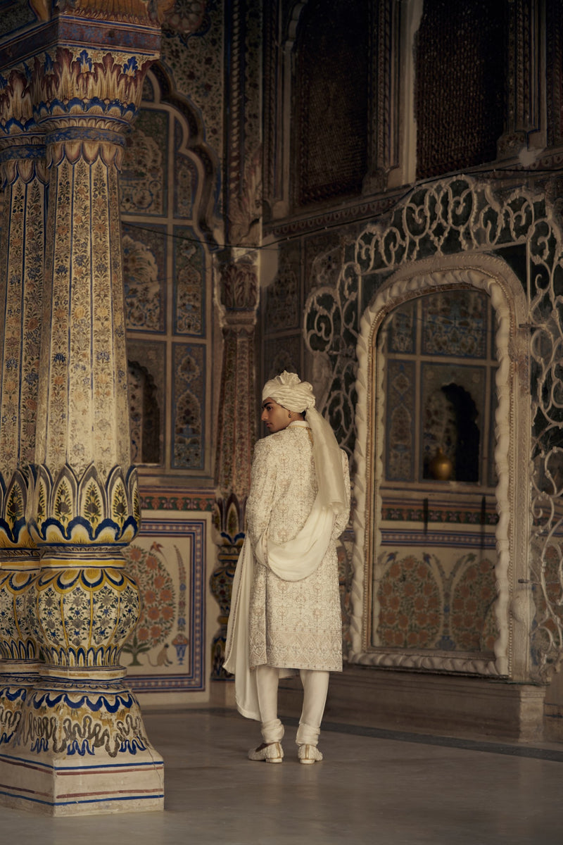 IVORY AND BEIGE RAW SILK SHERWANI SET WITH KURTA AND CHURIDAR AND AN OPTIONAL BELT, STOLE AND JUTIS