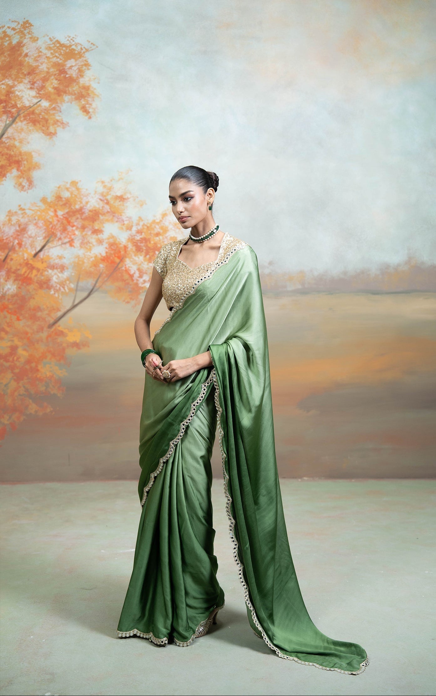 Woman in a green saree with a scenic background